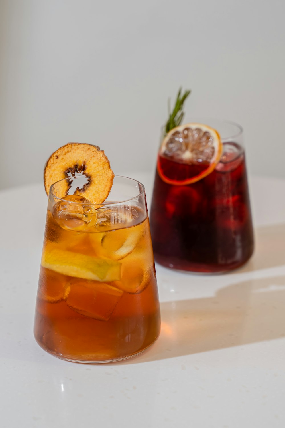 a glass of liquid with a fruit and a slice of bread on top