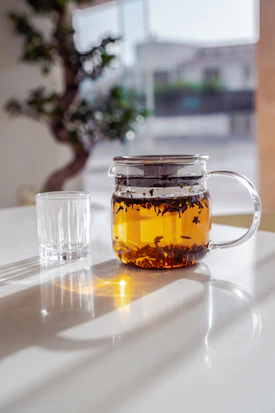 a glass mug with a yellow liquid in it