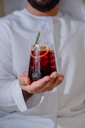 a man holding a glass of red liquid