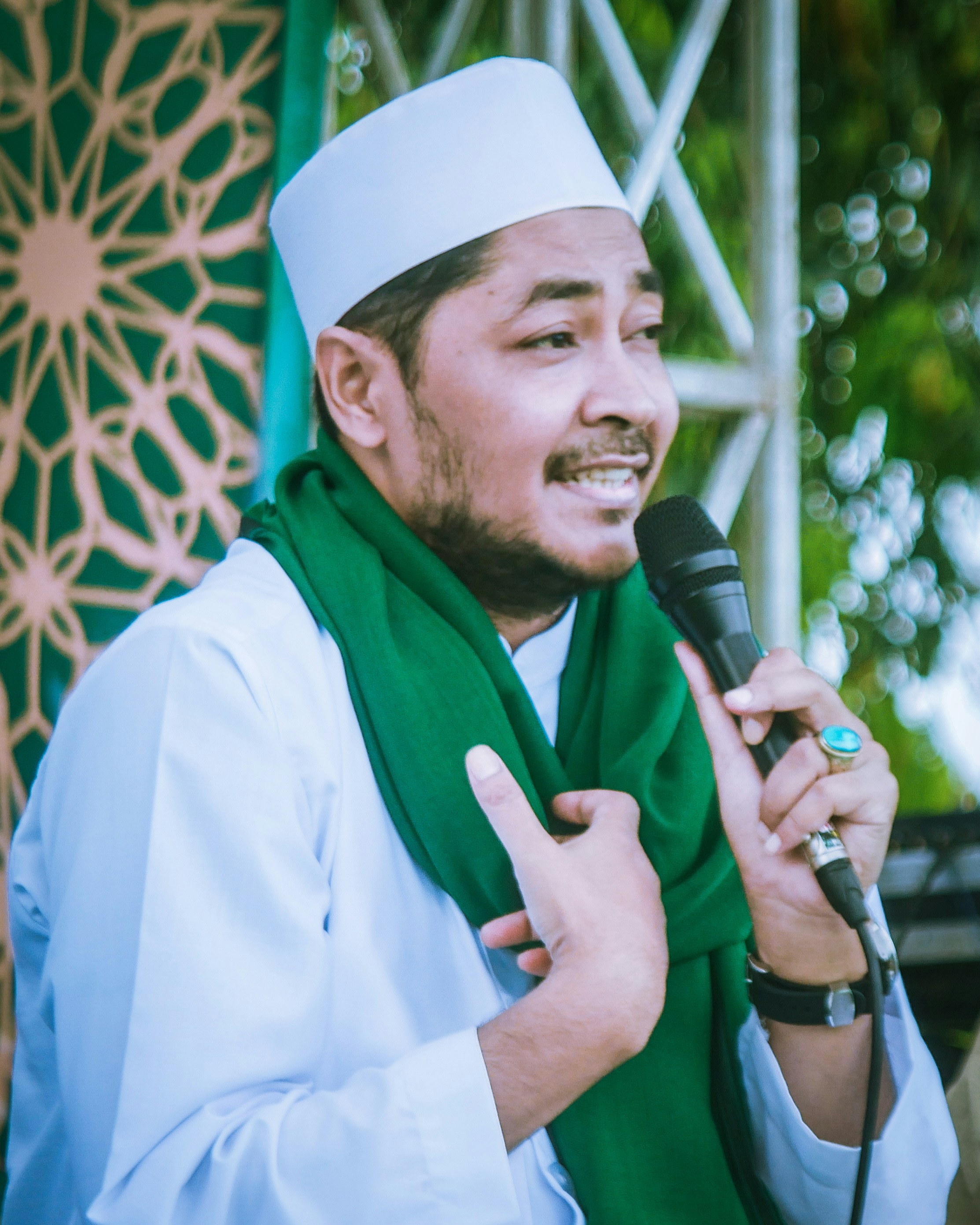 seseorang yang mengenakan jubah putih dan memegang mikrofon