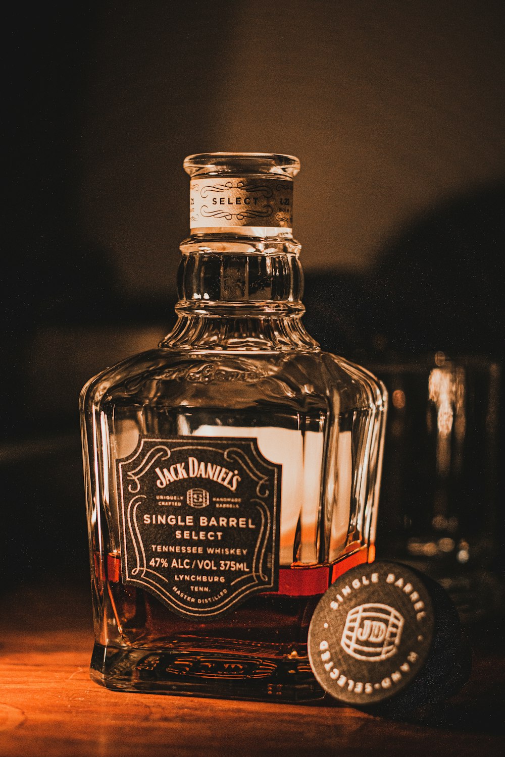 uma garrafa de álcool com Jack Daniel's ao fundo