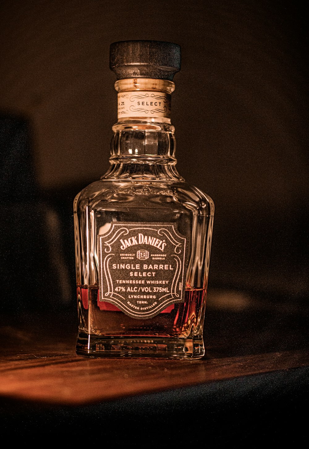 una botella de alcohol con Jack Daniel's de fondo