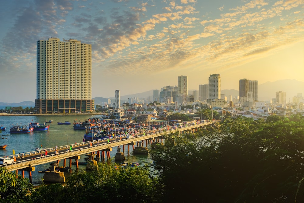 a bridge over a river with a city in the background