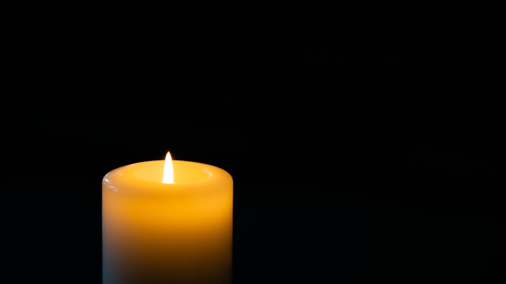 a lit candle in the dark