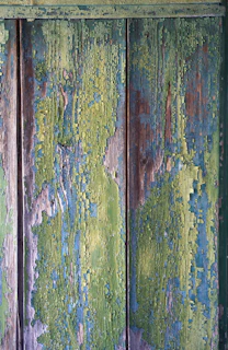 A detailed shot of a wood panel painting with subtle color fades and textured layers reminiscent of street art.