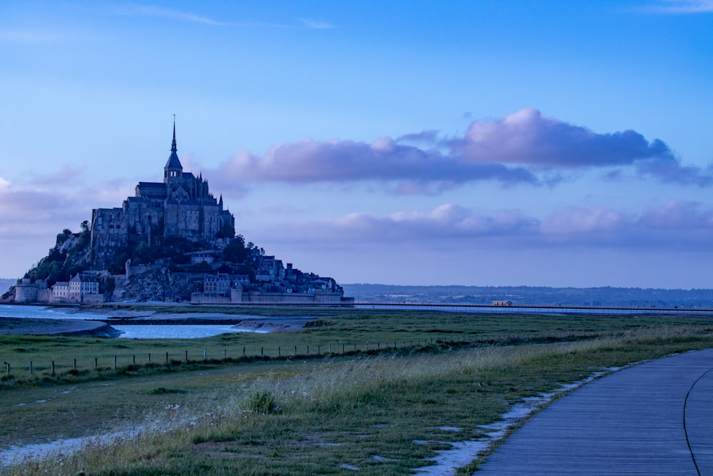 a castle on a hill with Mont Saint-Michel in the background