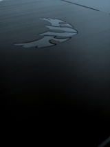 Finished custom engraved corporate merchandise displayed on a dark grey surface with subtle green accents.