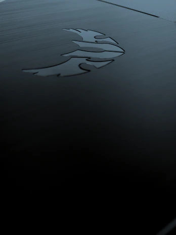 Laser-engraved metal card resting on a dark textured surface, highlighting intricate Egyptian-inspired patterns.