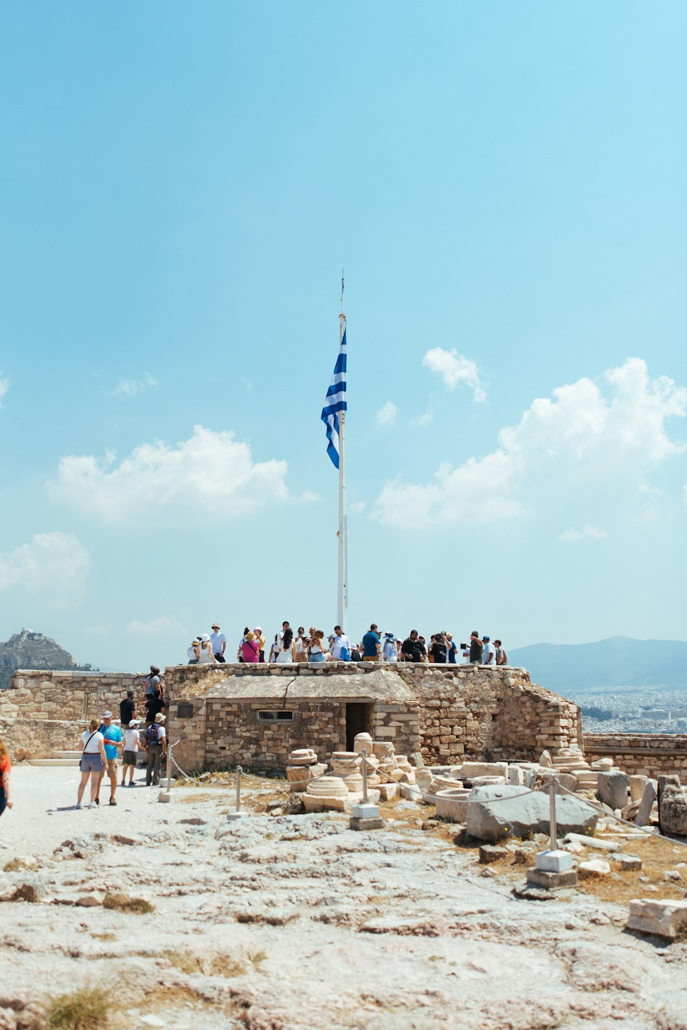 Un grupo de personas de pie en un muro de piedra con una bandera