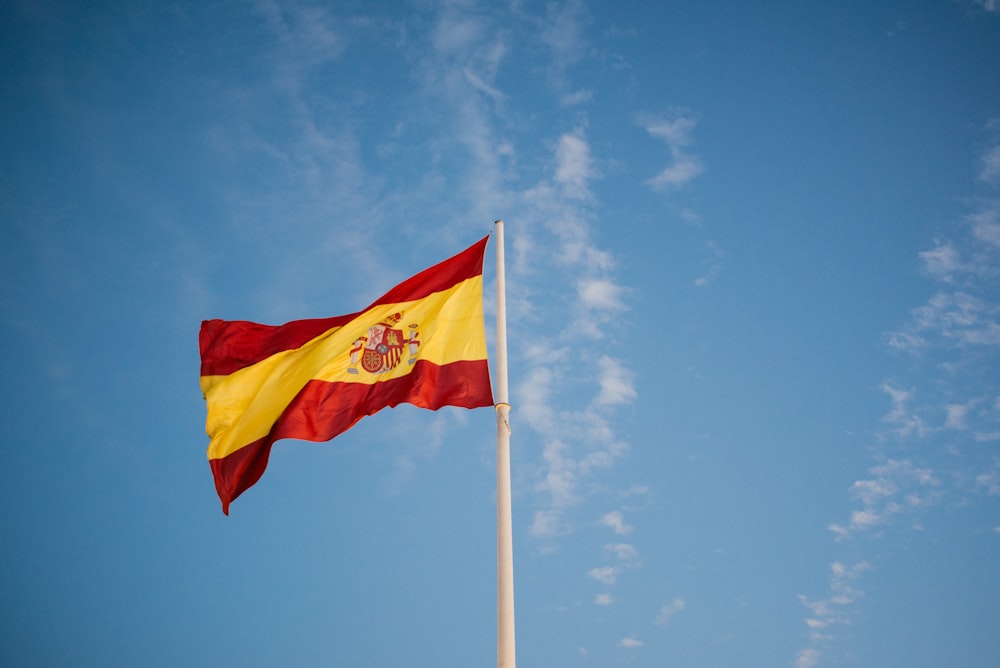 a red and yellow flag on a flagpole