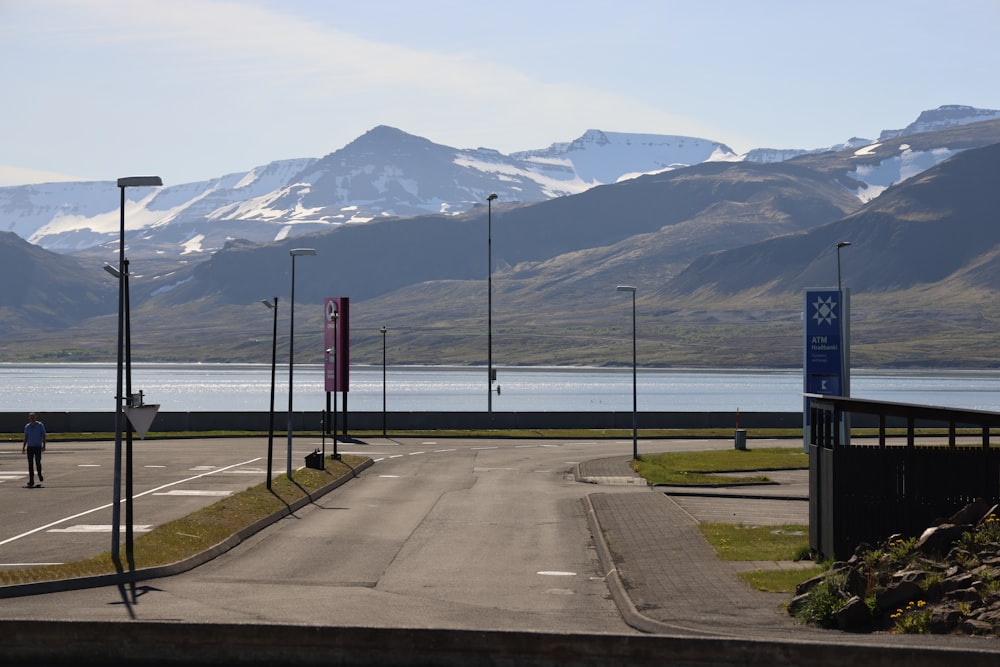 a road with signs and a body of water in the background