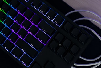 A sleek high-end mechanical keyboard with customizable RGB lighting on a wooden desk.