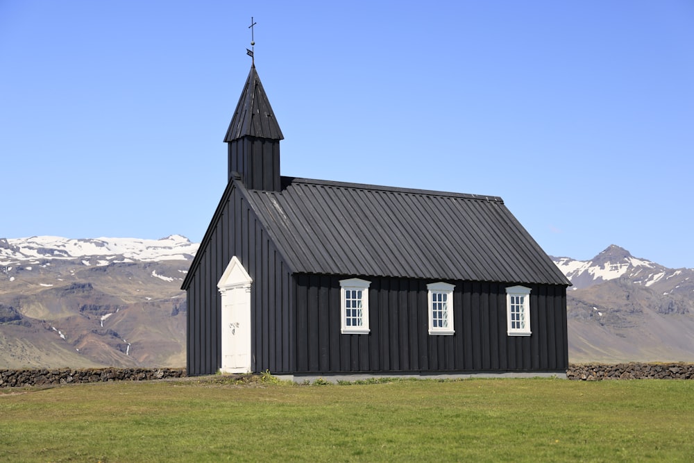 a black and white building with a steeple and a cross on top