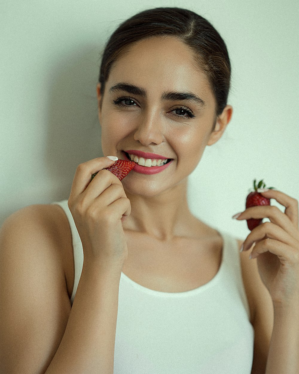 a woman holding a strawberry