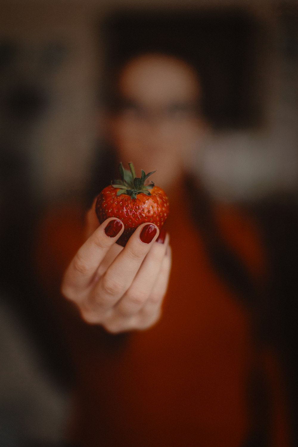 a person holding a strawberry