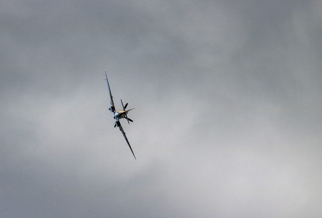 a helicopter flying in the sky, WWII Spitfire banking after a flyby at the Stonor Park supercar and classics day