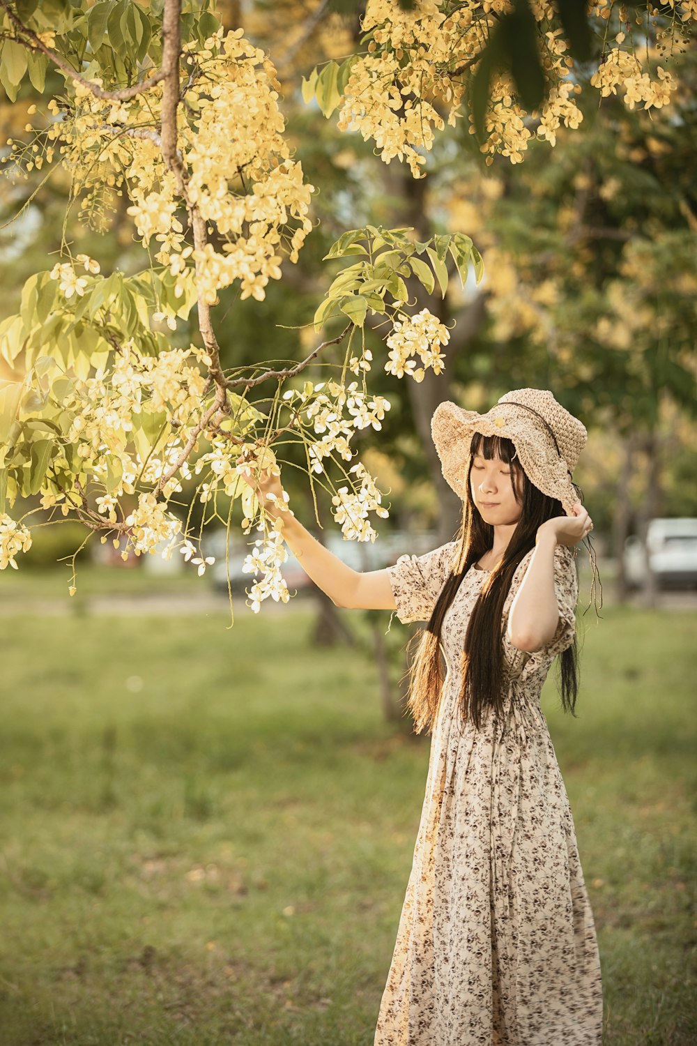 Une femme en robe tenant un arbre avec des fleurs
