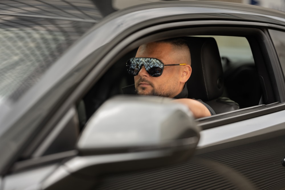 a man wearing sunglasses and sitting in a car