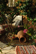 A cozy outdoor nook featuring a wooden bench stool and a woven decorative basket filled with fresh flowers.