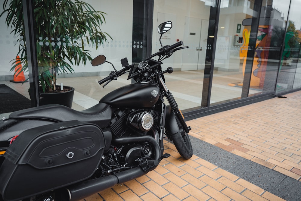 a black motorcycle parked on a brick sidewalk