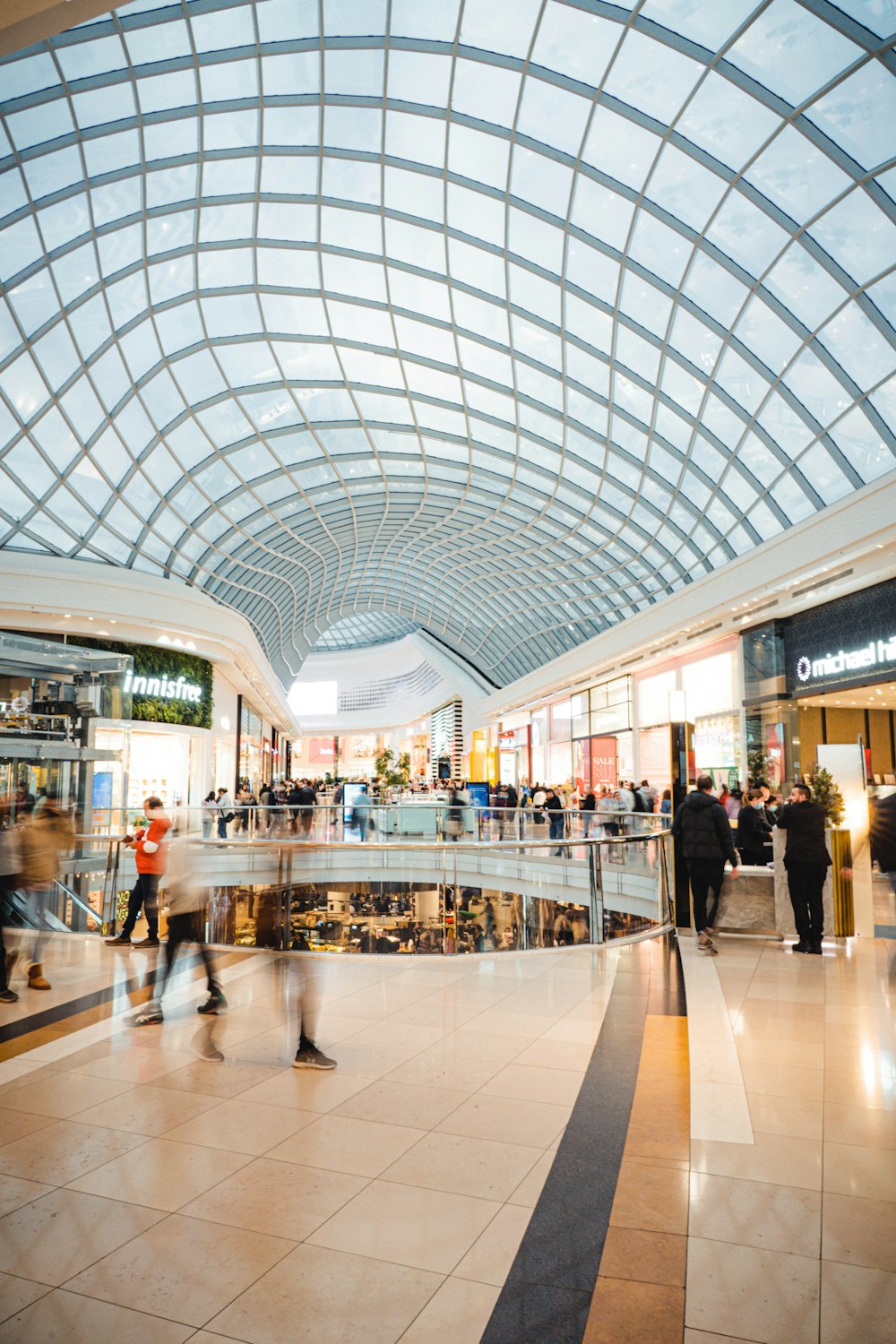 a large glass ceiling with people walking around with The Core Shopping Centre in the background