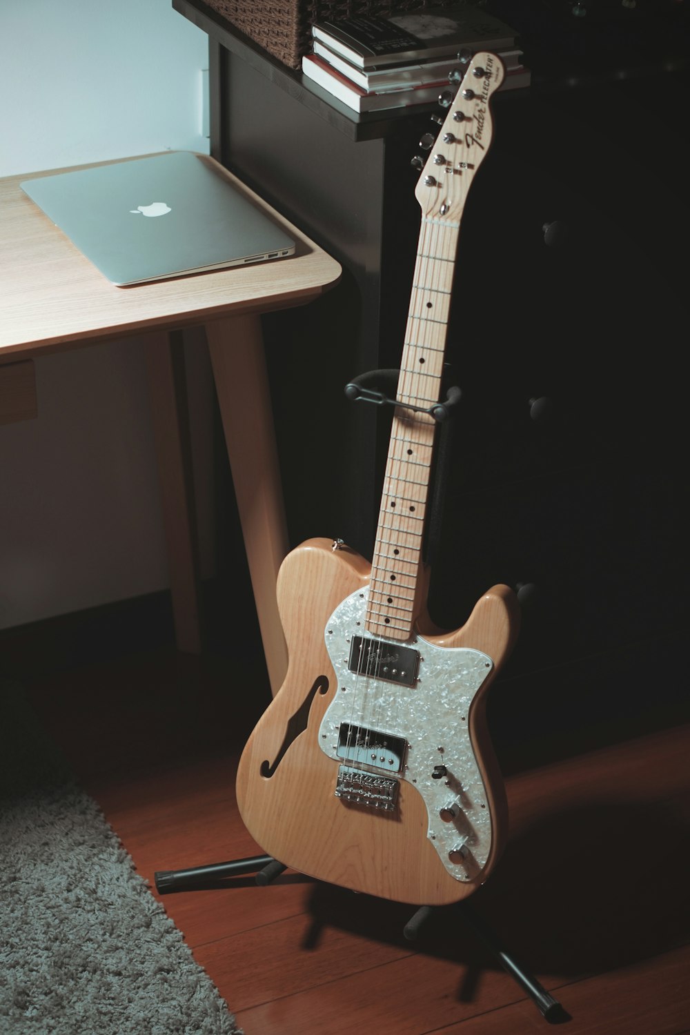 a guitar leaning against a desk