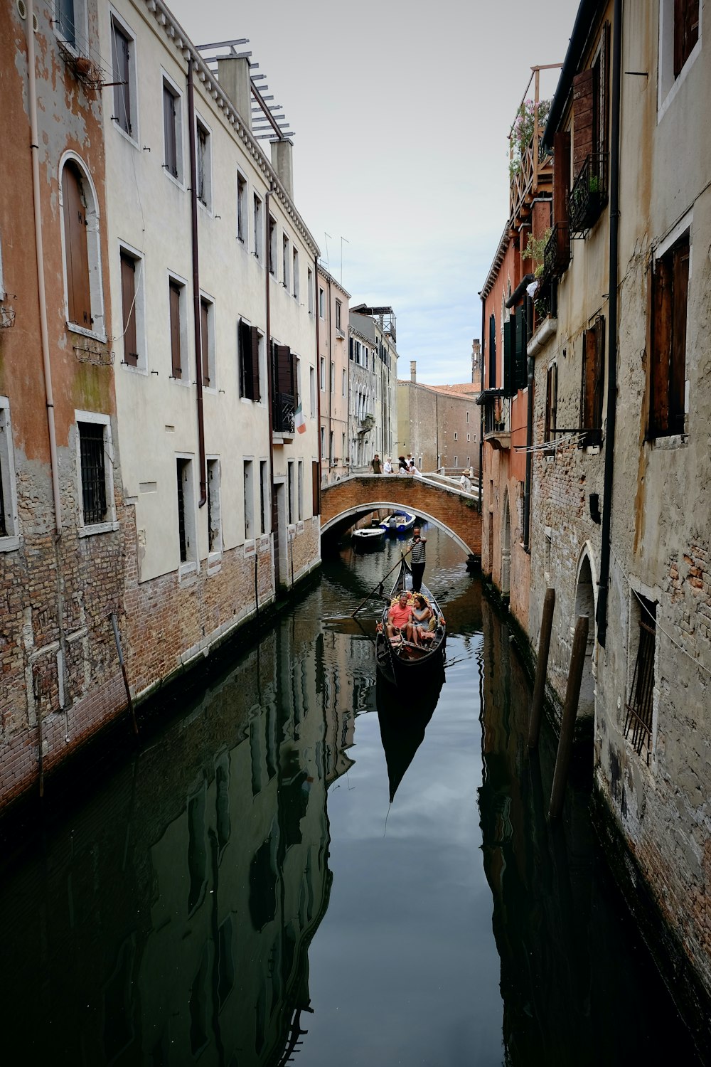 a boat on a canal between buildings