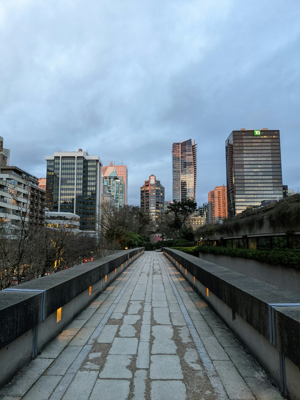 a stone walkway with a city in the background