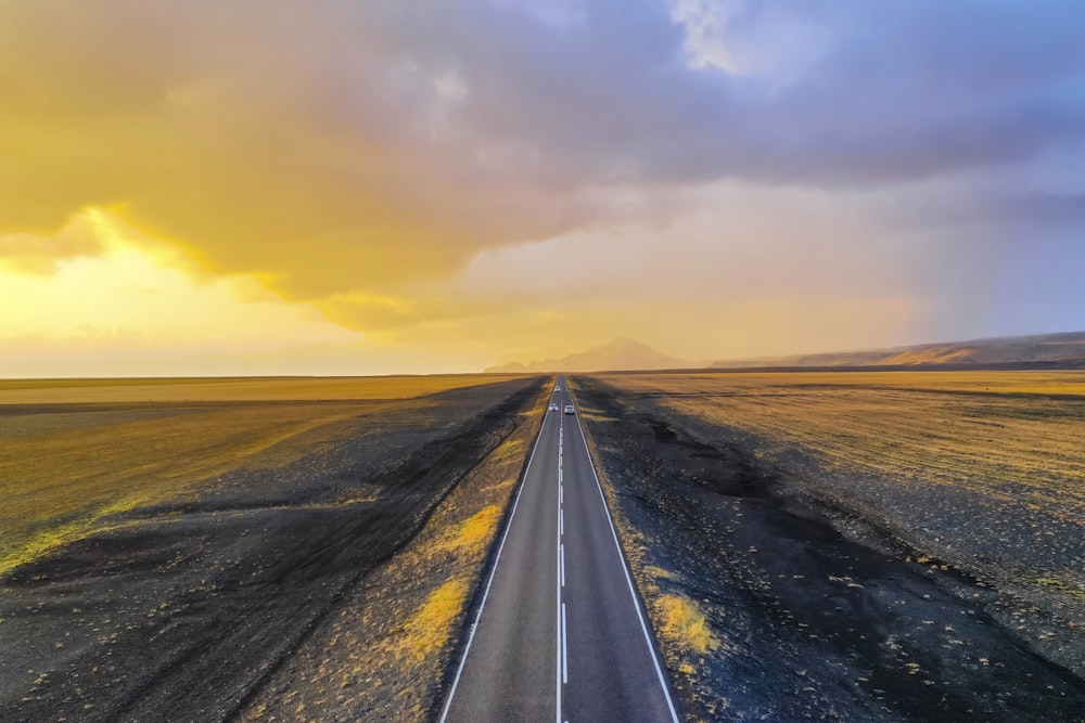 a road with a flat area with a cloudy sky above