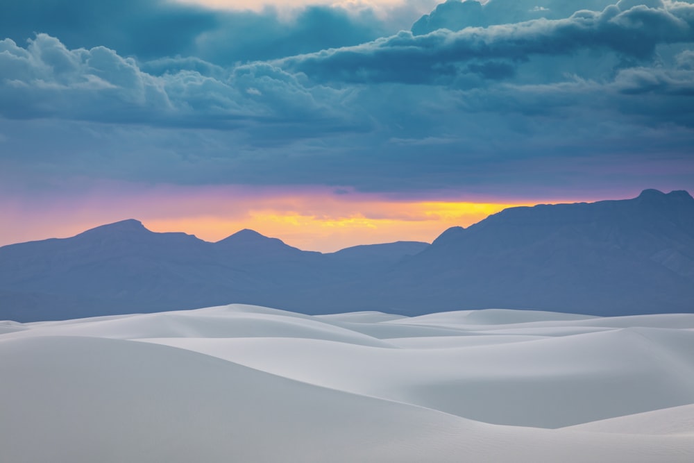 a snowy landscape with mountains in the background