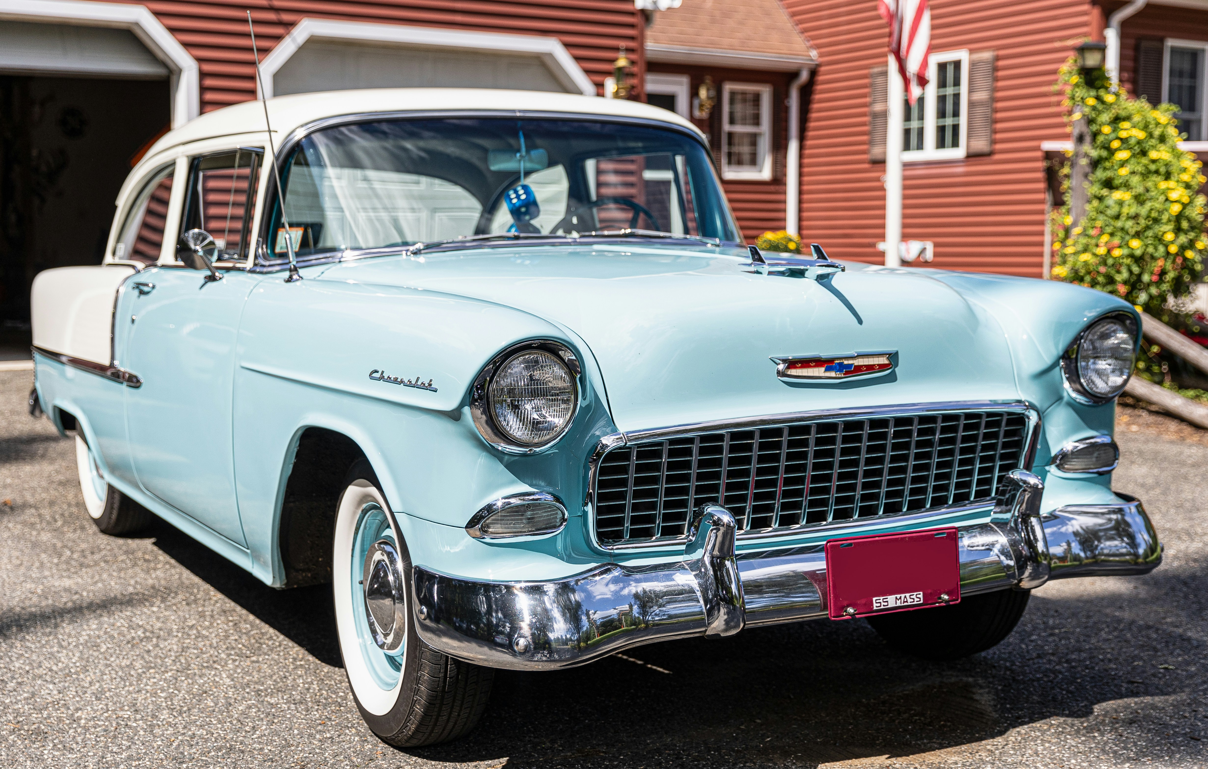 a blue car parked in front of a house