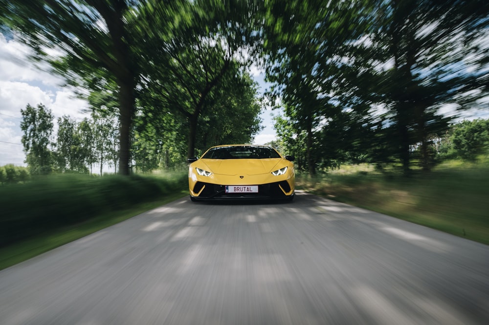 a yellow sports car on a road