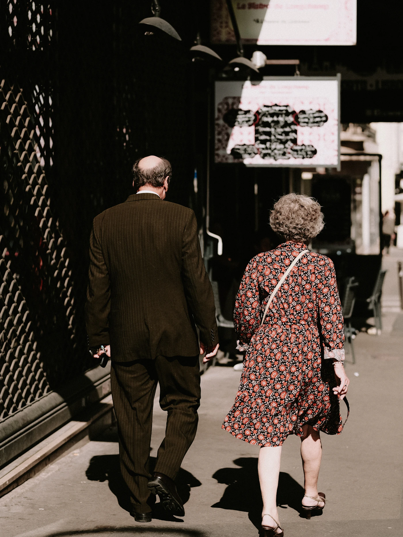 Older couple walking together from behind