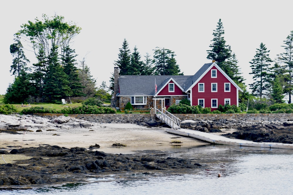 a red house on a rocky shore