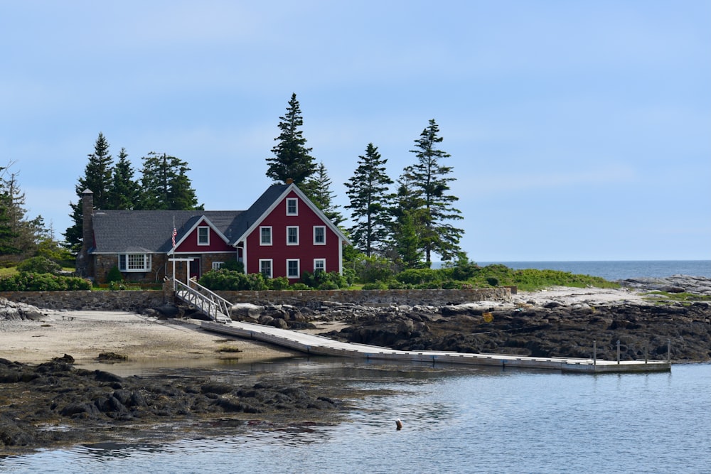 a red house on a rocky shore