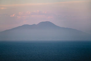 Serene landscape painting depicting a misty morning by the sea with soft pastel colors.