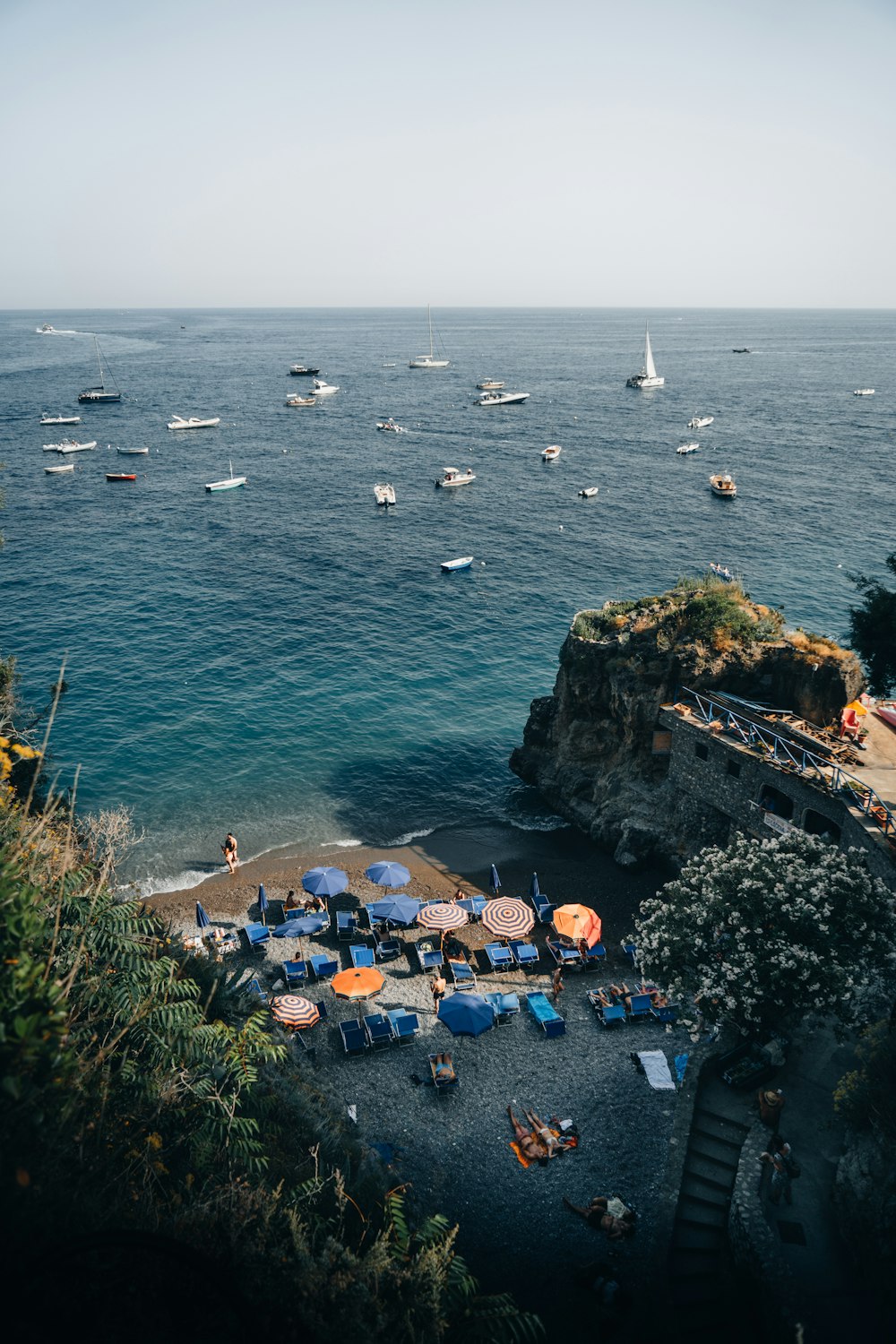 a beach with umbrellas and boats