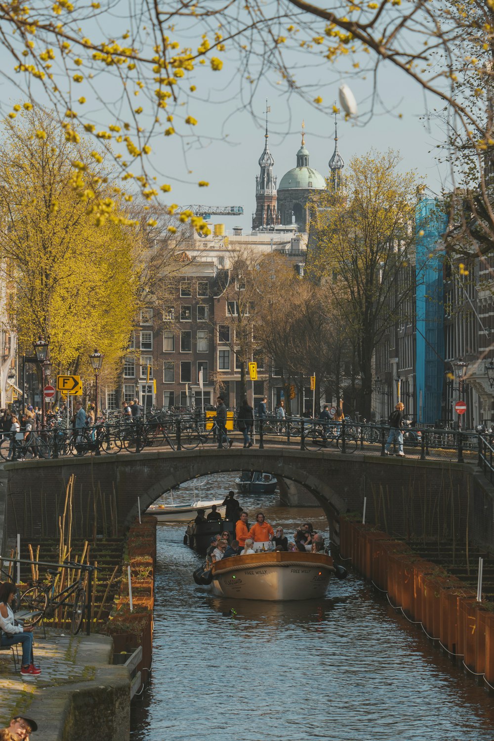 a boat on a river with people on it and buildings in the background