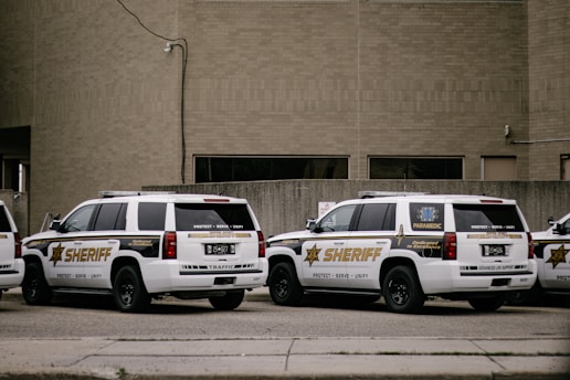 a couple of white cars parked in front of a building
