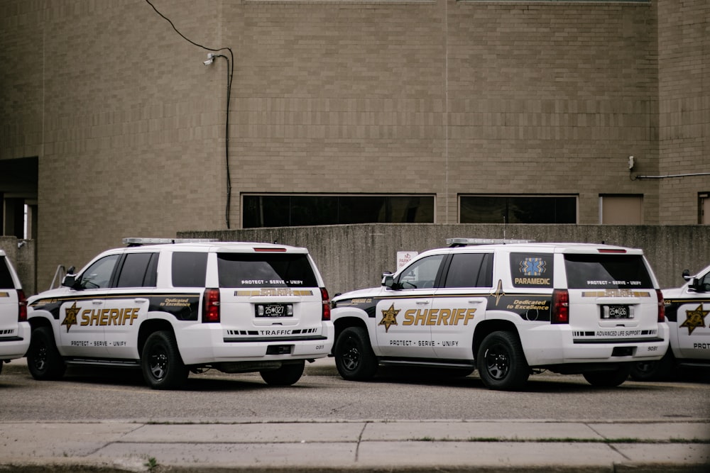 a couple of white cars parked in front of a building