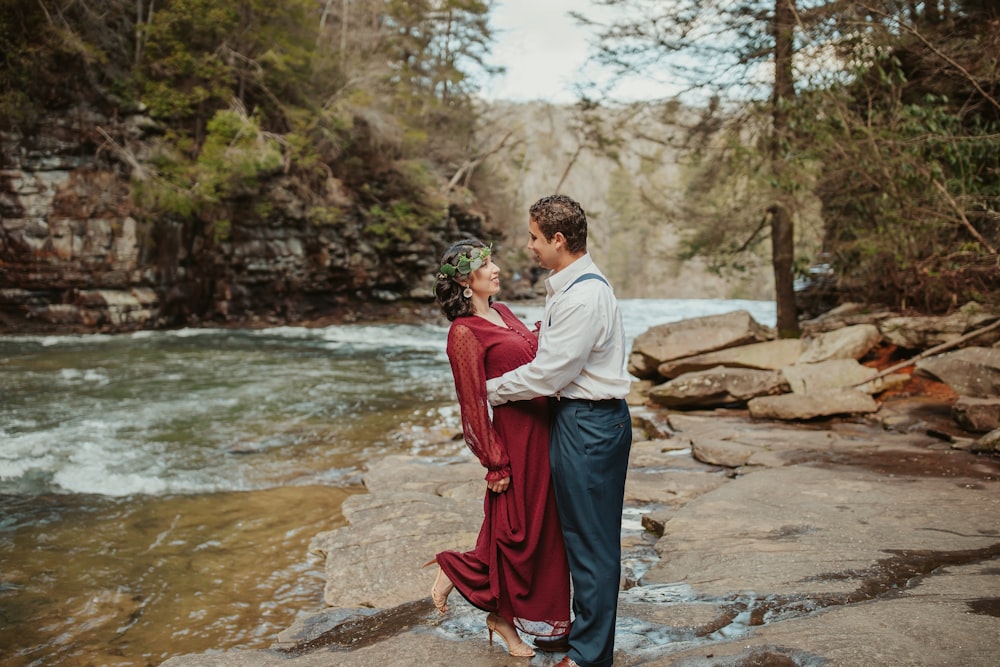 a man and woman kissing by a river