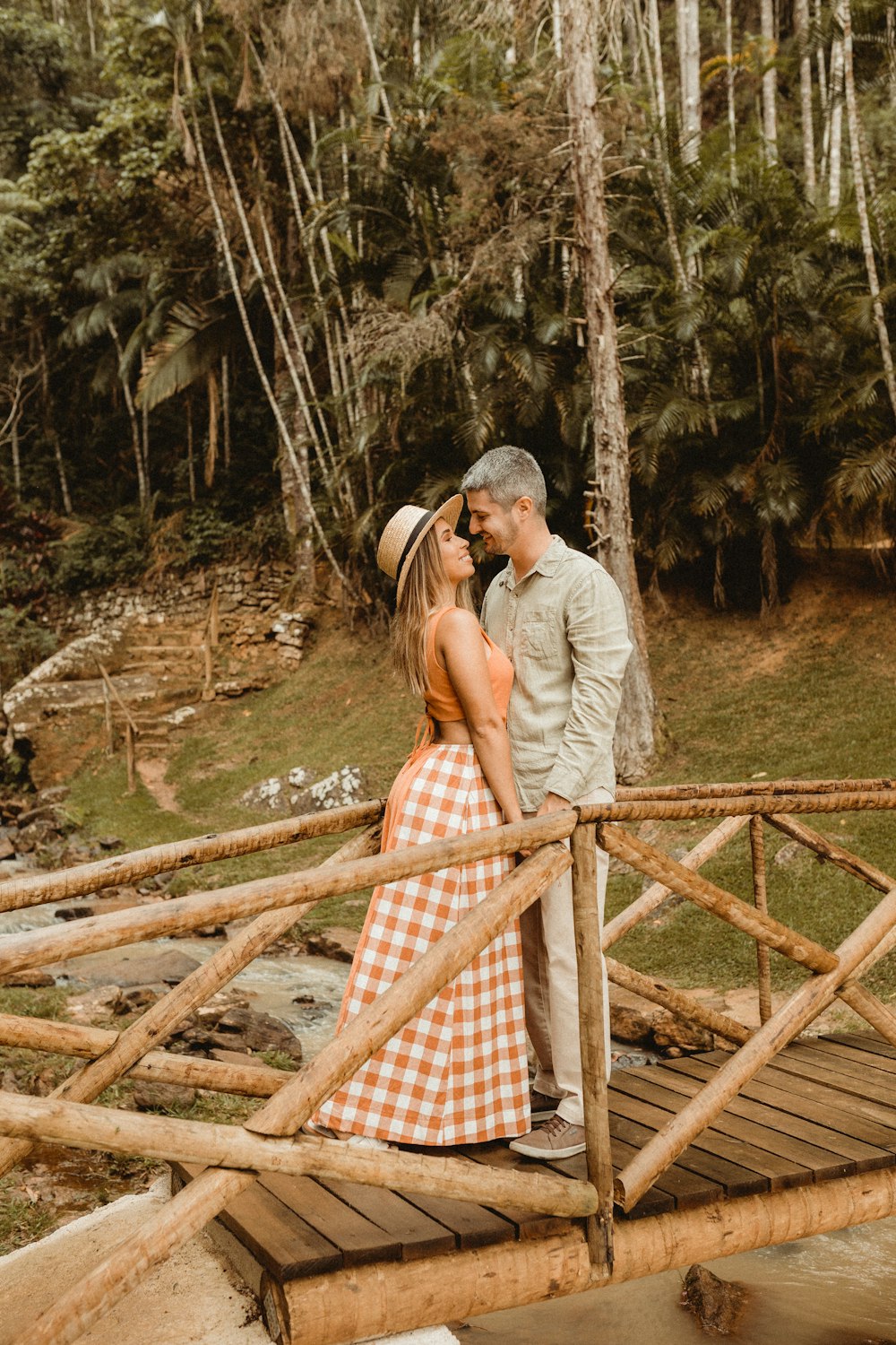 a man and woman kissing on a bridge