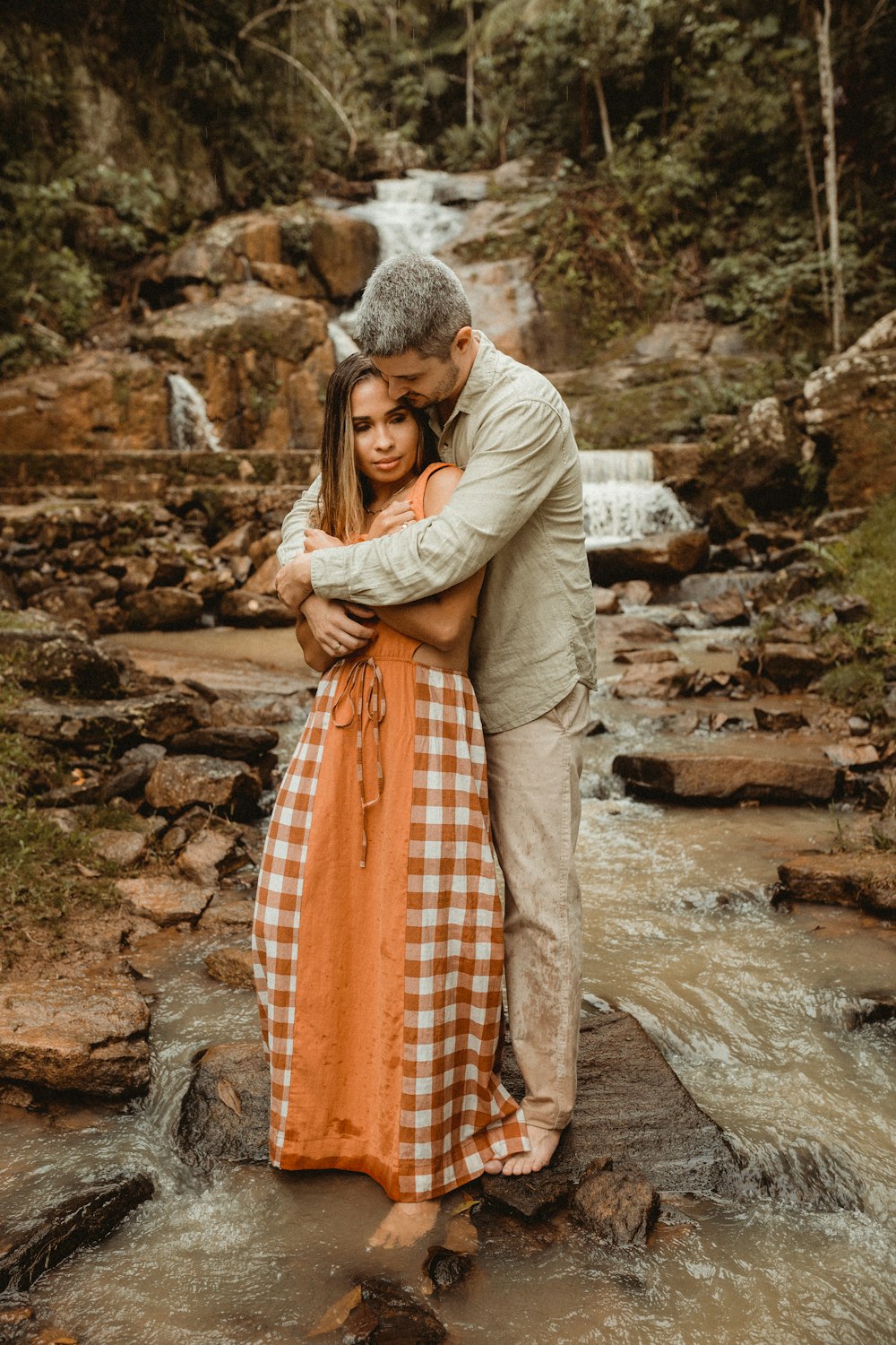 a man and woman hugging in a stream