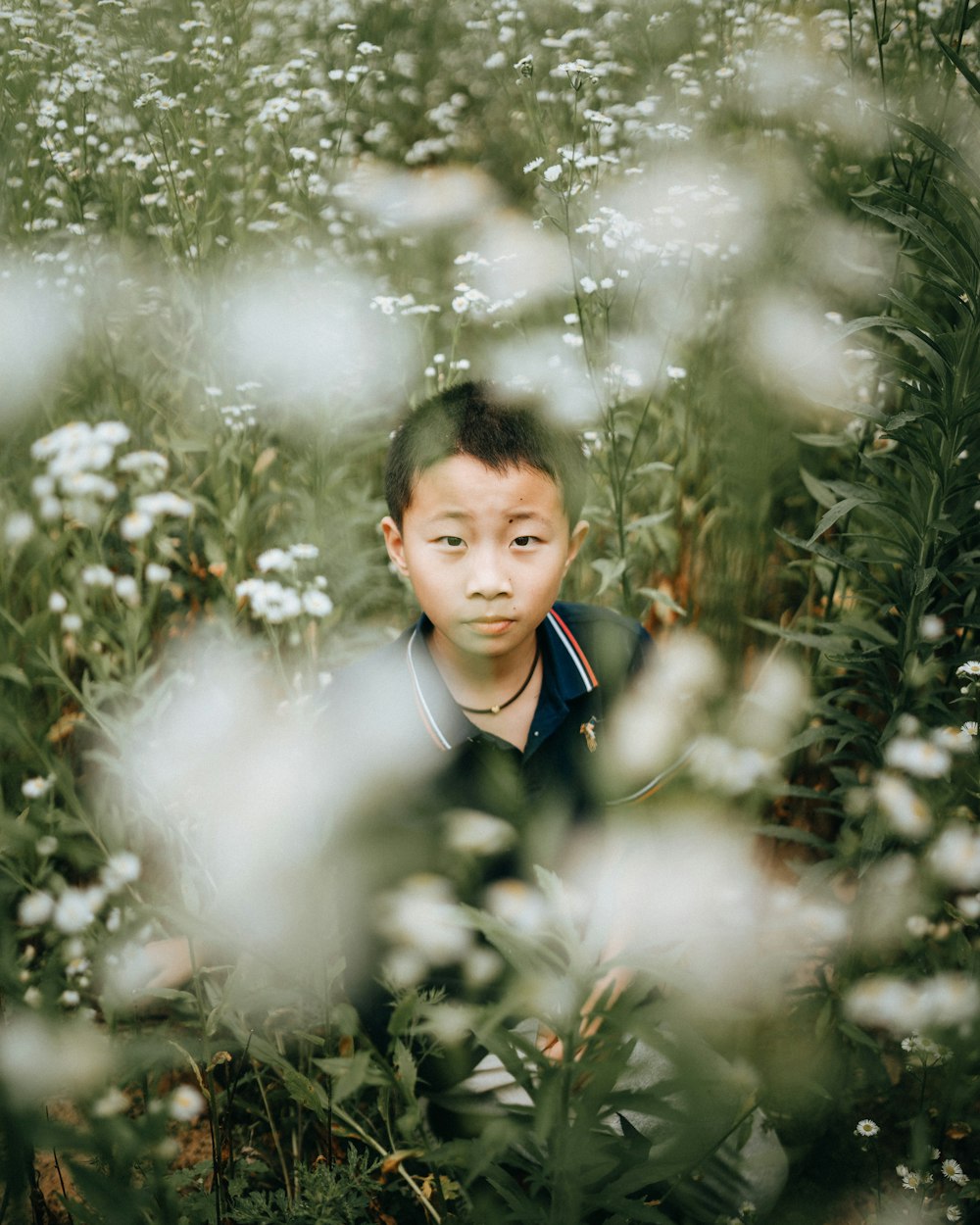 a boy in a uniform surrounded by white flowers