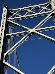 Engineers inspecting a steel bridge framework under clear skies.