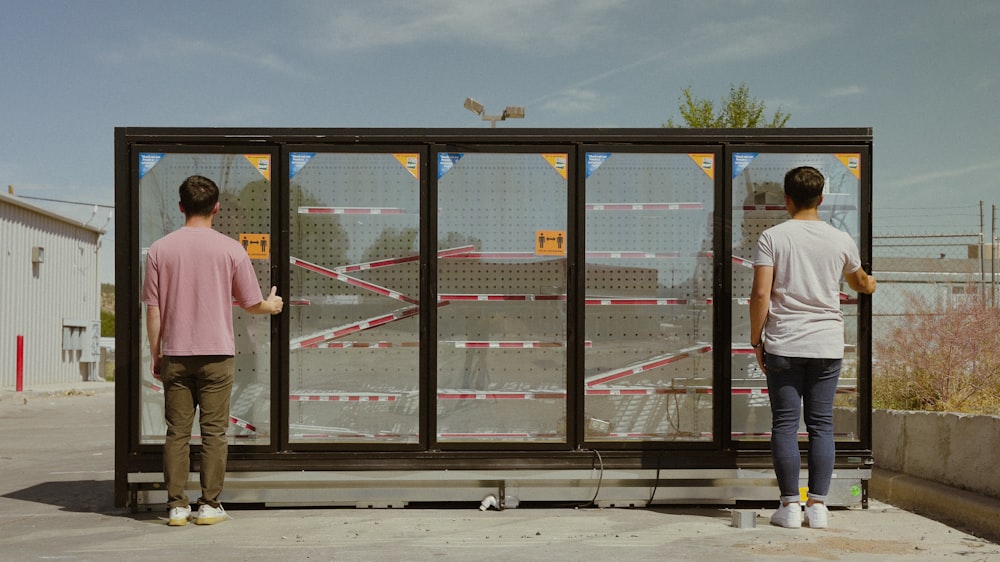 two people standing in front of a glass door