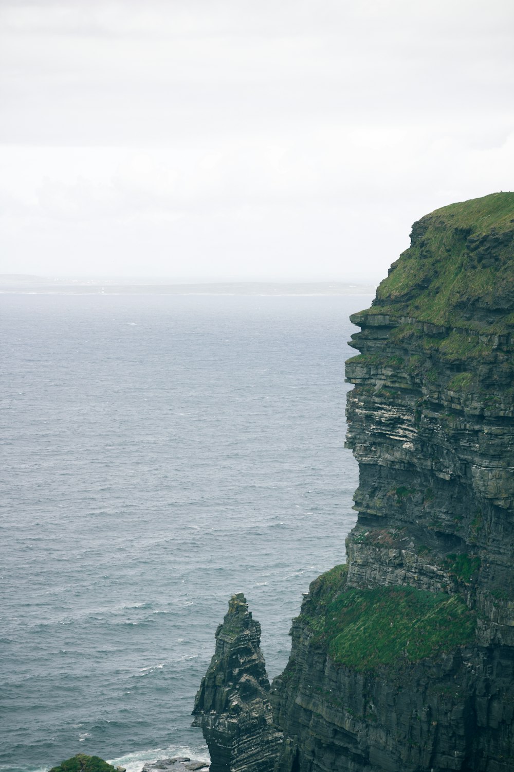 a cliff side with a body of water below