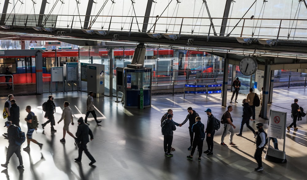 a group of people walking in a train station