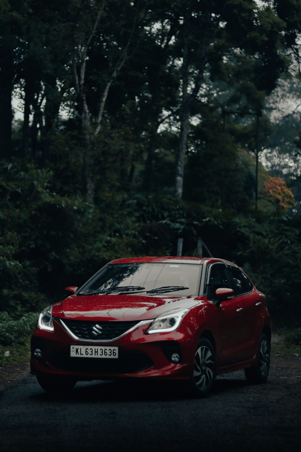 a red car parked in a wooded area