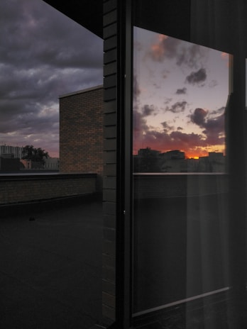 Close-up of a sleek tempered glass window reflecting a desert sunset.